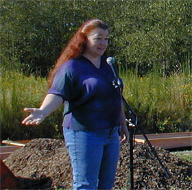 Allison tells foxglove story in front of raised beds